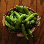 Raw Shishito Peppers in a wooden bowl
