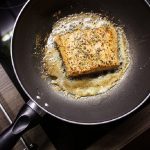 Salmon being cooked in a heated pan