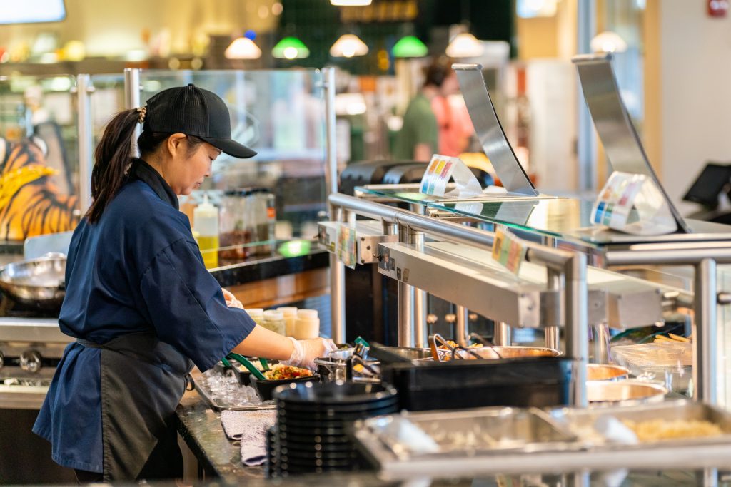 Student worker dishing up food behind the counter